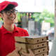 delivery driver handing pizza boxes to woman
